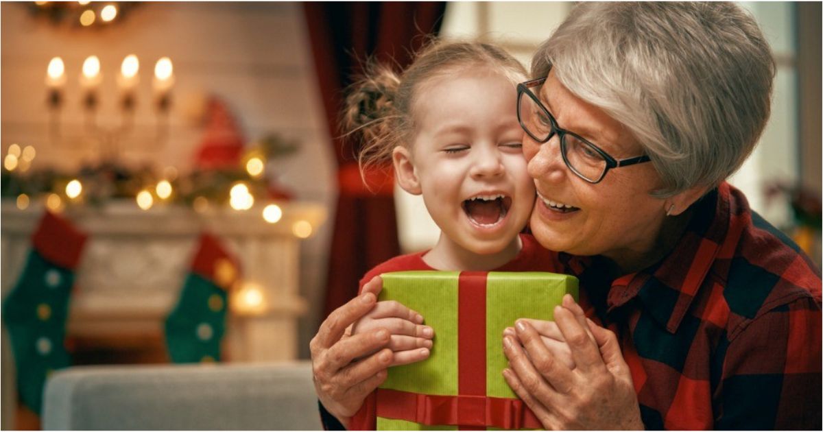 A young girls opens a holiday gift with her father