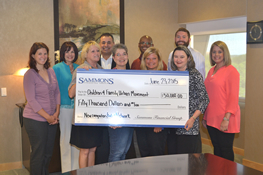 A group photo of Sammons Financial Group employees holding a $50,000 check donated to Children and Family Urban Movement.