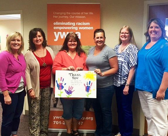 A group photo of YWCA Cass Clay Emergency Shelter employees holding a thank you note.