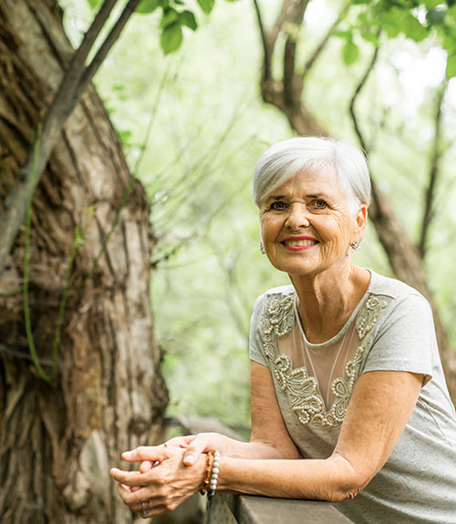Woman leaning on railing in forest area