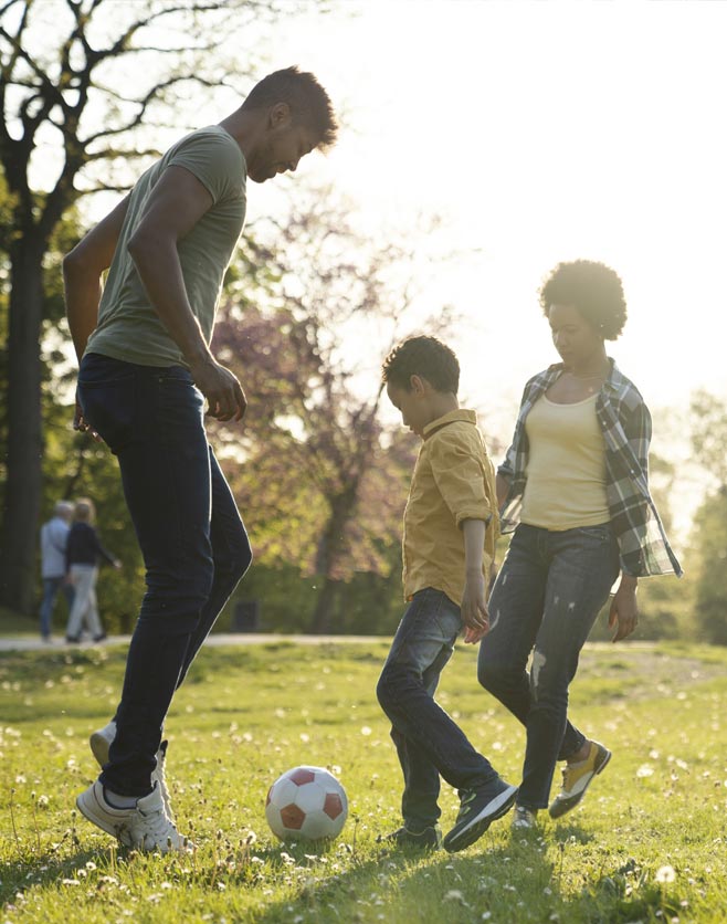 Man, women and kid playing soccer