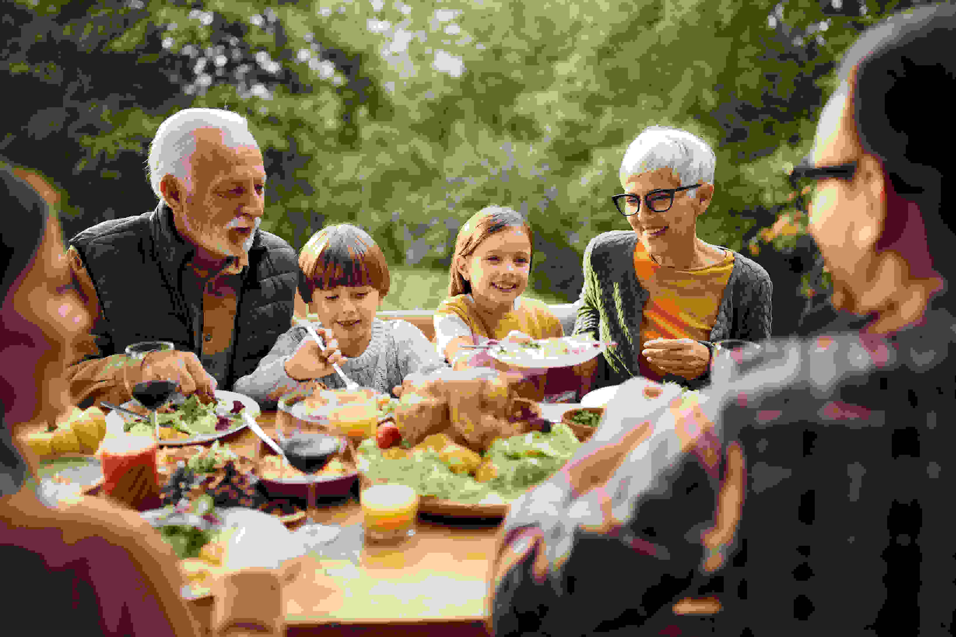 Older couple enjoying a meal with their grandchildren outdoors