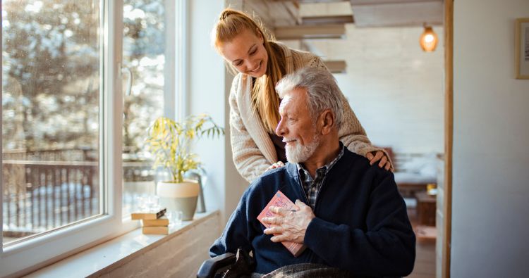 A woman puts her hands the the shoulders of an older relative.