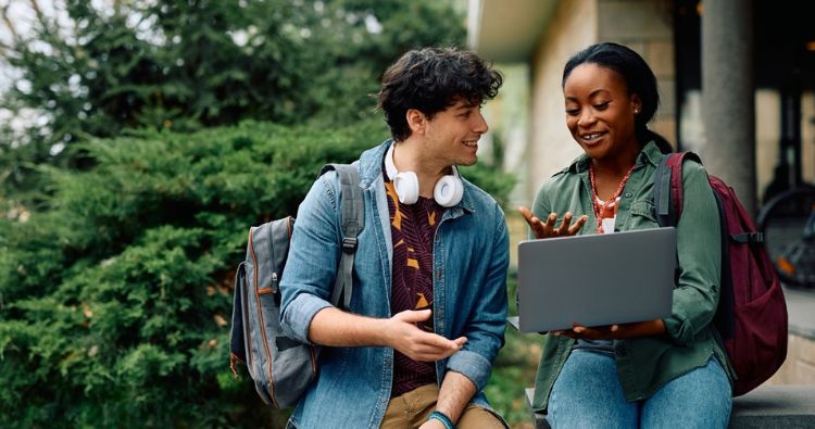 Two college girls walk together on campus.