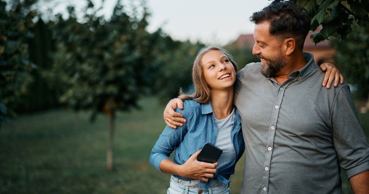 A father embraces his teenage daughter