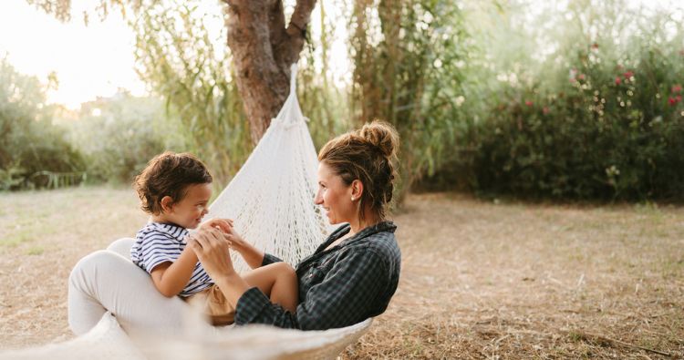 A mother sits with her son in a hammock