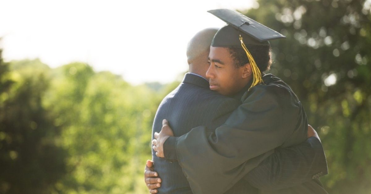A young graduate hugs his father