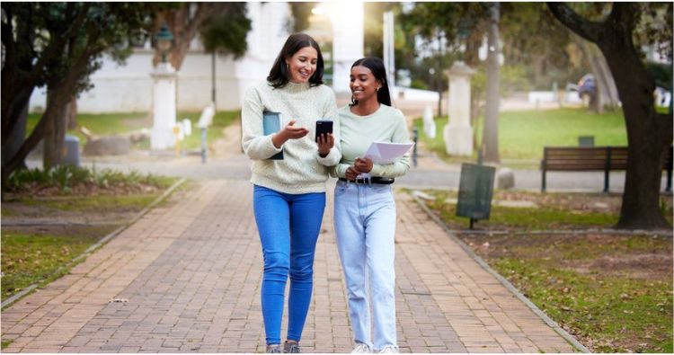 Two college girls walk together on campus.