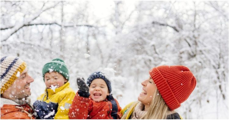 A young family have fun catching snowflakes on their tongues.