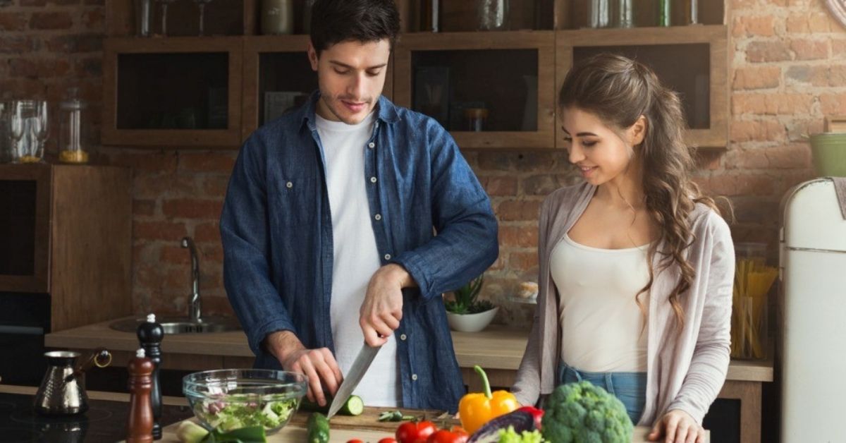 A young couple cooks a heart-health meal together.