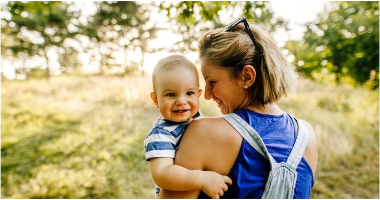 A woman holds a smiling baby.