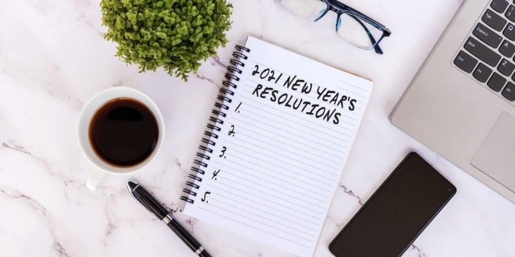 a notepad with a checklist for 2021 resolutions