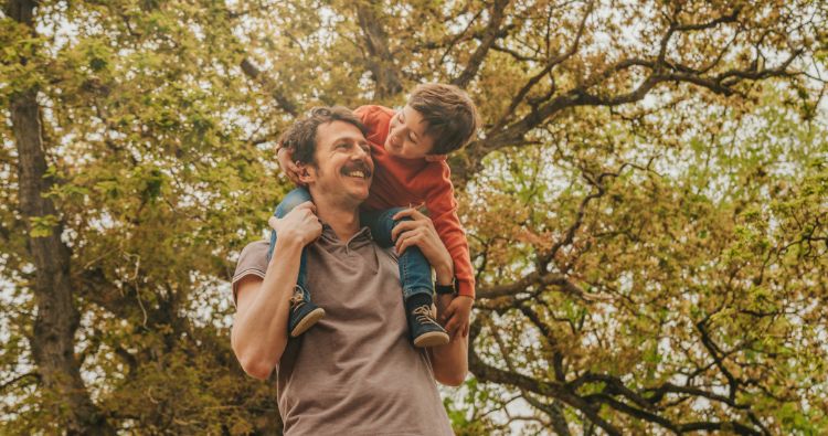 A father carrying his child on his back outdoors