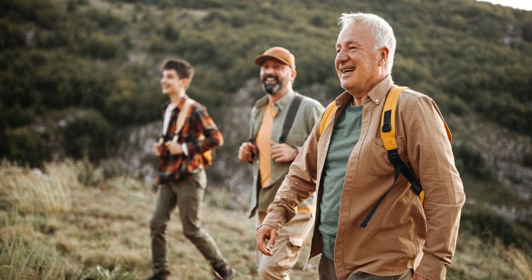 Three generations of a family go hiking in the hills.