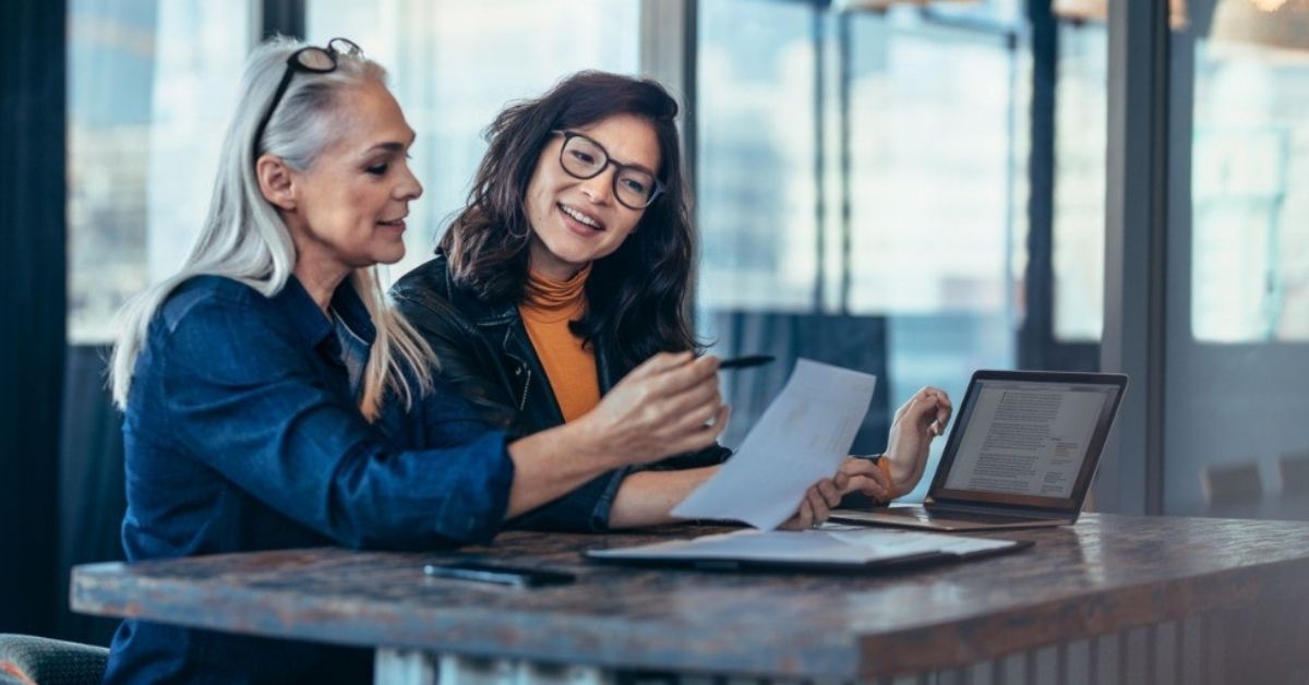 A middle-aged woman works with a young agent on her retirement plan