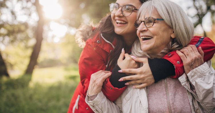 A young woman hugging her grandmother.