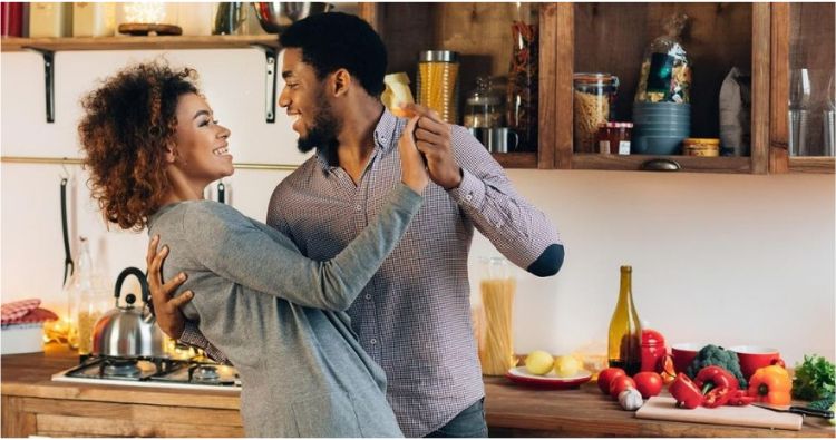 A young couple dances together in their kitchen