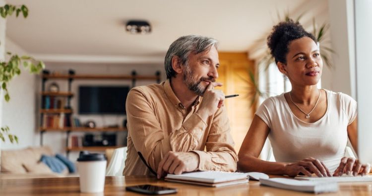 A husband and wife explore their options on a computer.