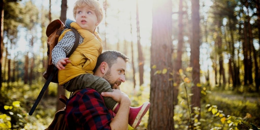 Mature father and toddler walk in the woods