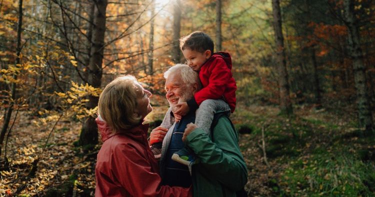 An older couple give their grandson a piggyback ride.