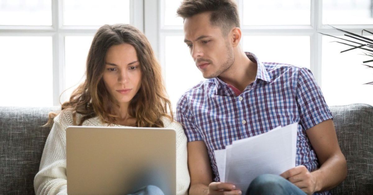 A young couple look concerned while planning their estate.