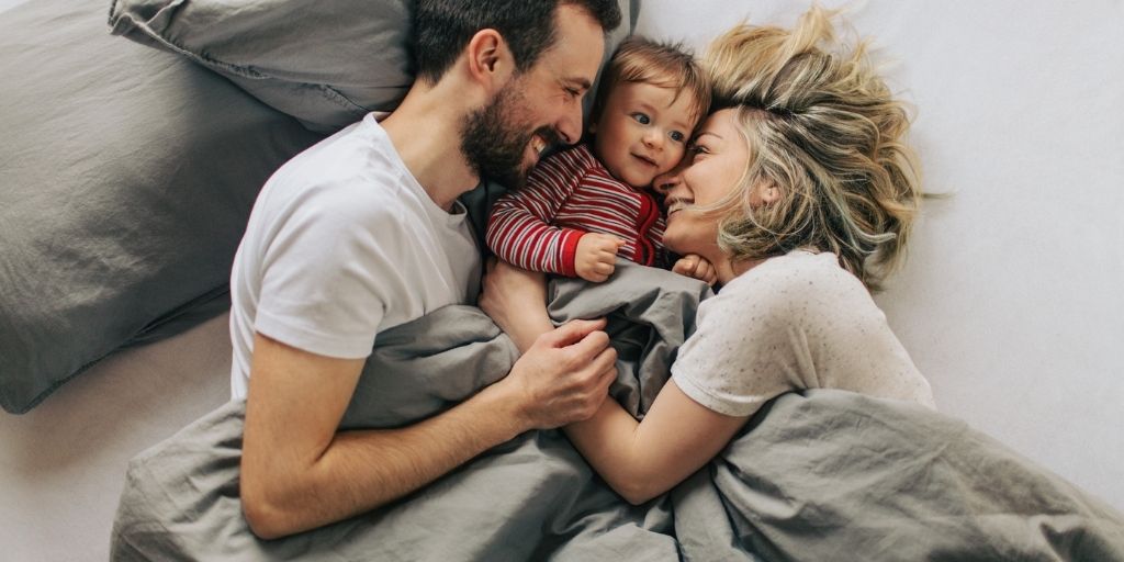 A young couple hold their newborn child.