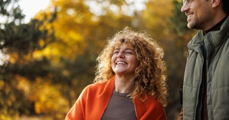 A young couple stand together in the golden hue of sun light.