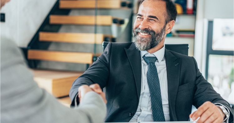 A man shakes a recruiters hand after accepting a job offer.