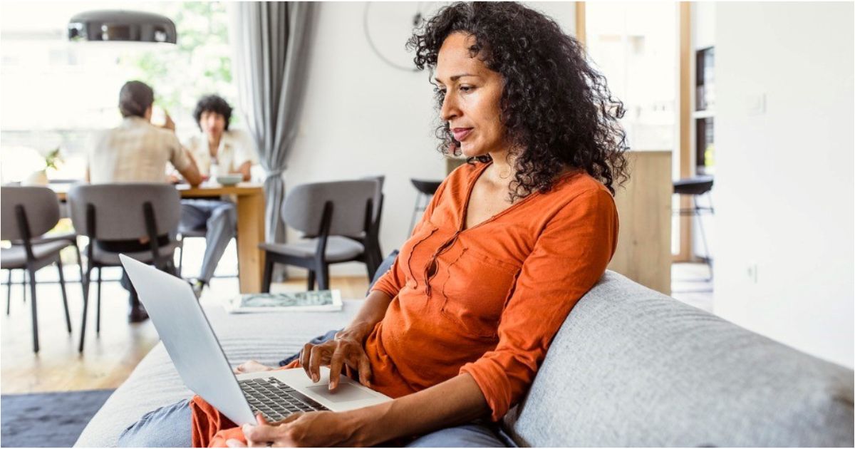 A woman looks at her computer screen while reviewing her finances.