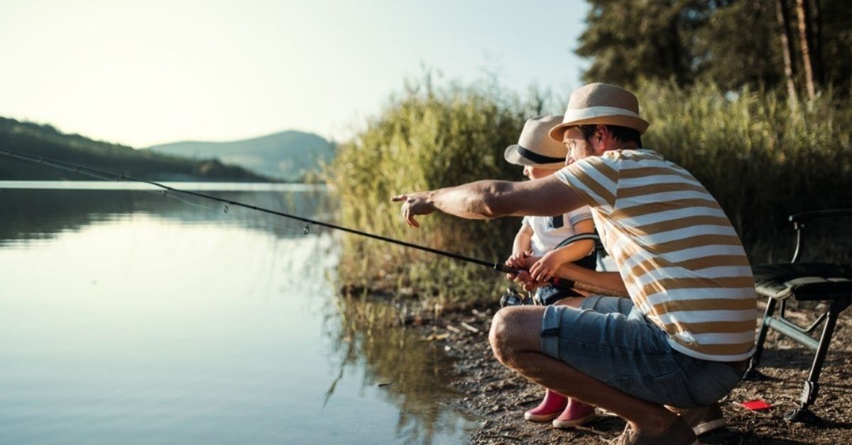 A young father teaches his son to fish