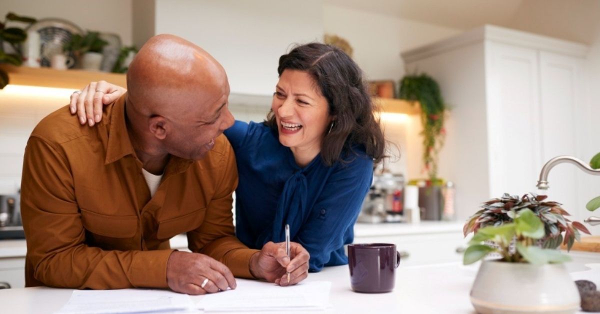 A middle-age couple look over financial documents together.