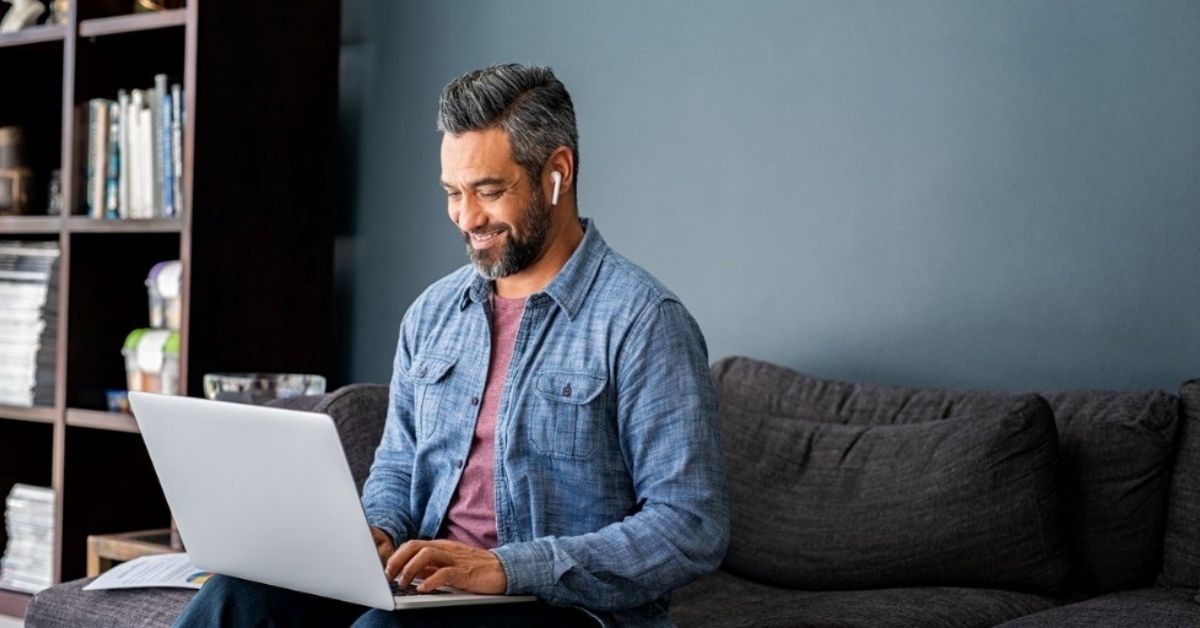 A man looks through financial documents on his computer