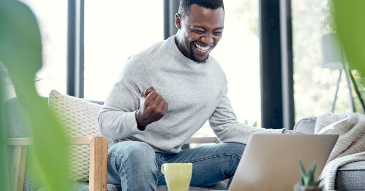 A young man smiles while doing his taxes.