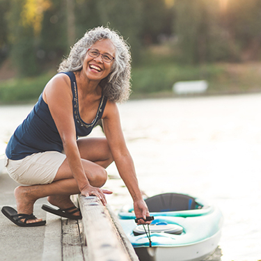 Women on a dock holding a kayak